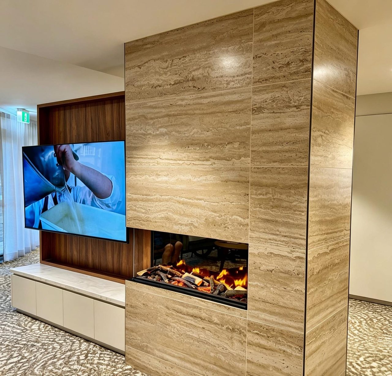 Travertine-clad fireplace feature with walnut joinery