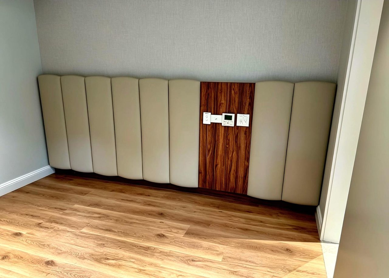 Soft upholstered wall panelling with walnut insert