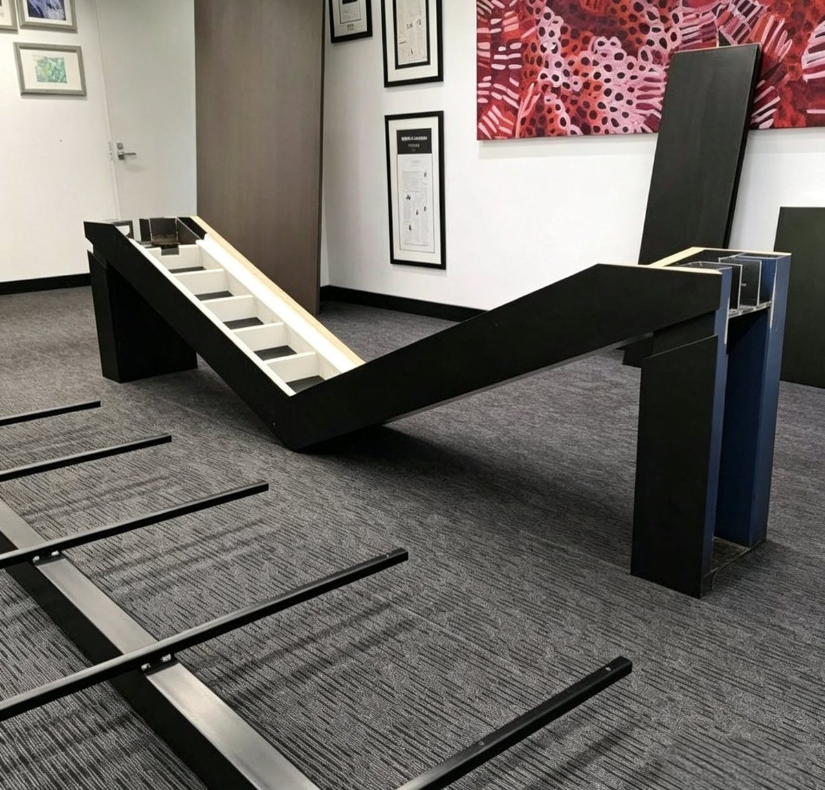 The architectural black base frame of the boardroom table during assembly