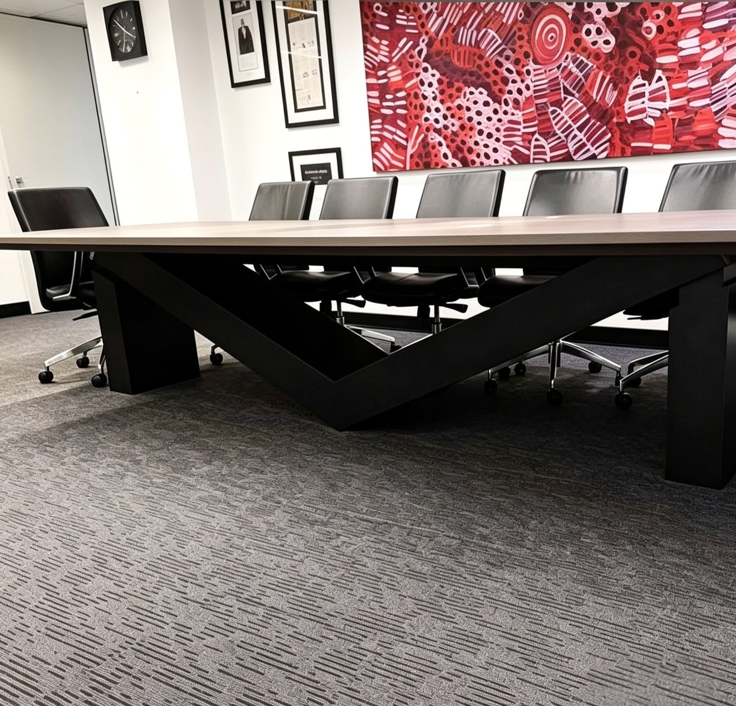 Bespoke boardroom table with timber top and angular black base, built for the Managing Director of Meriton