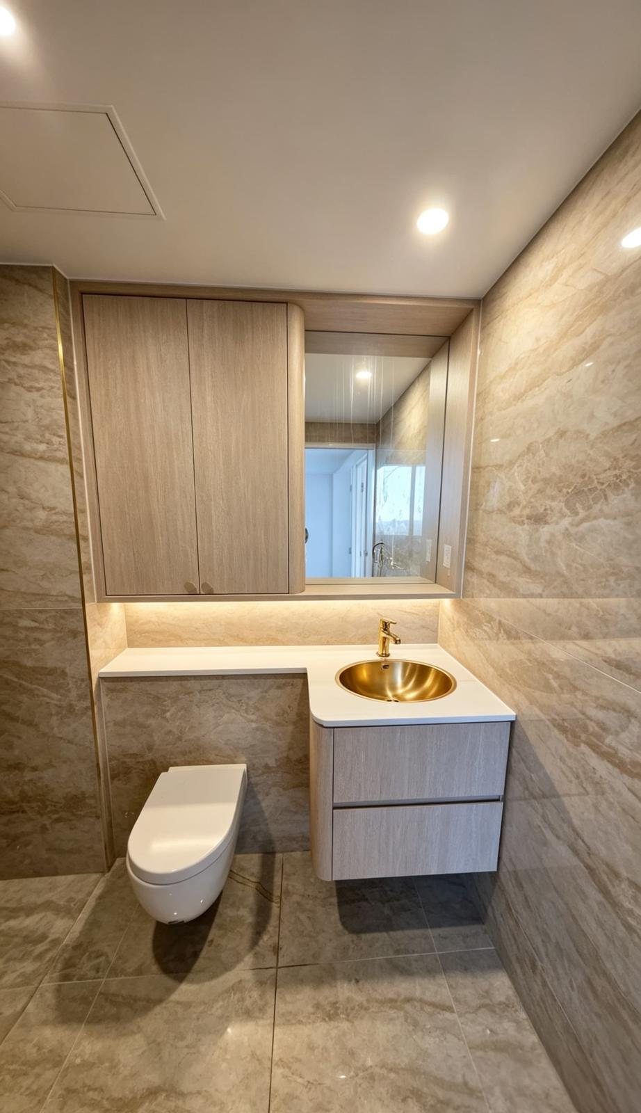 Powder-room vanity with stone top and brass basin